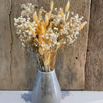 verschiedene Trockenblumen in grauer Vase