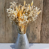 verschiedene Trockenblumen in grauer Vase