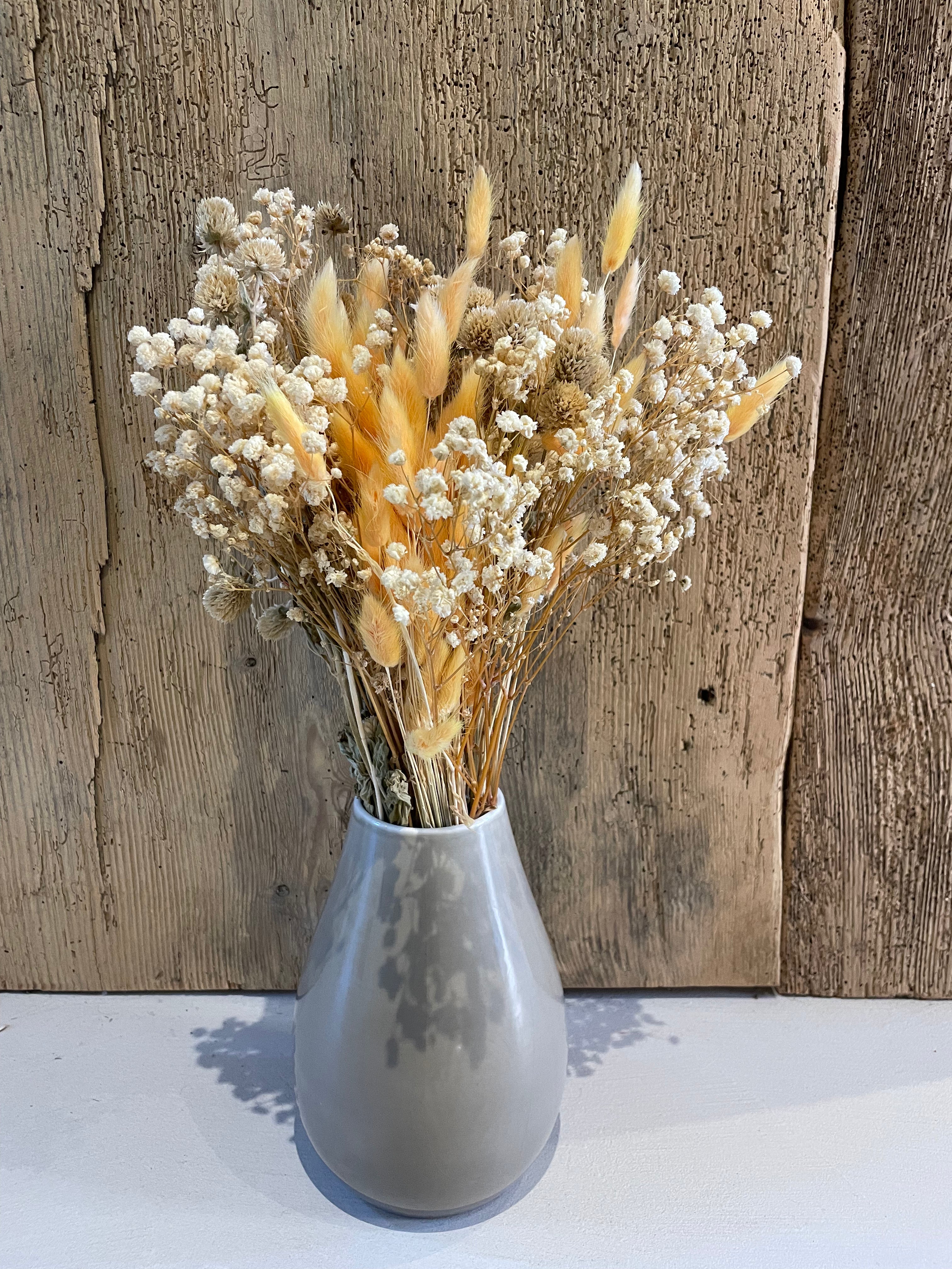 verschiedene Trockenblumen in grauer Vase